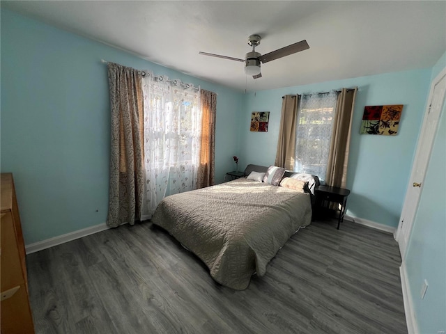 bedroom with multiple windows, dark hardwood / wood-style floors, and ceiling fan