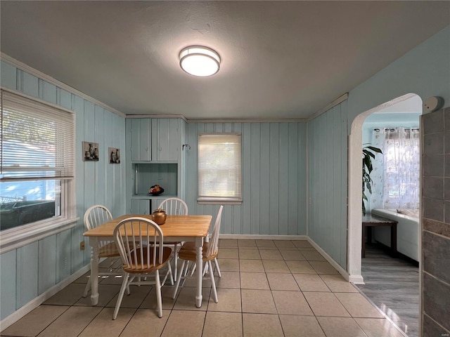 tiled dining room featuring ornamental molding