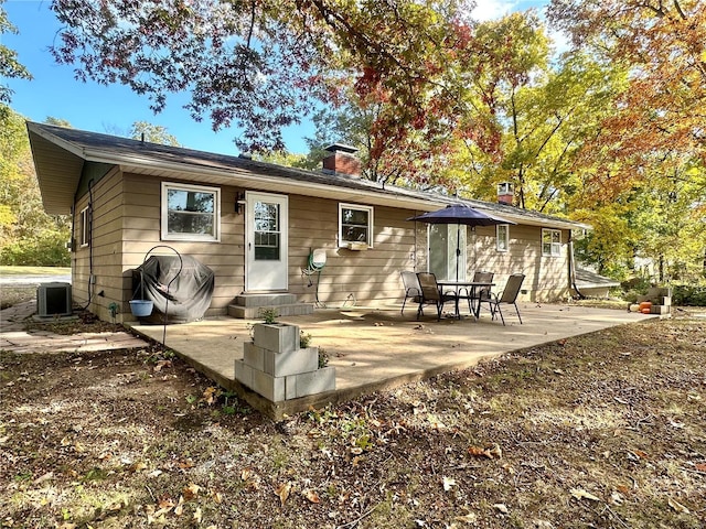 rear view of property with a patio area and central AC