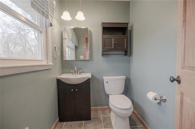 bathroom with tile patterned flooring, vanity, toilet, and a notable chandelier