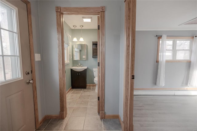 bathroom featuring baseboard heating, tile patterned flooring, vanity, and toilet