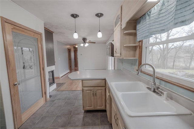 kitchen with ceiling fan, sink, light brown cabinets, kitchen peninsula, and pendant lighting