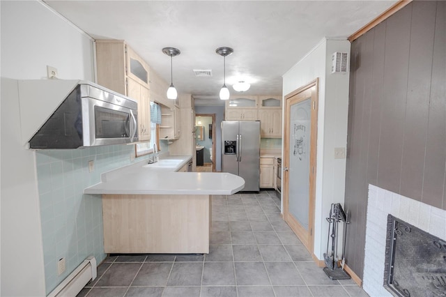 kitchen featuring light brown cabinets, hanging light fixtures, stainless steel appliances, a baseboard heating unit, and kitchen peninsula