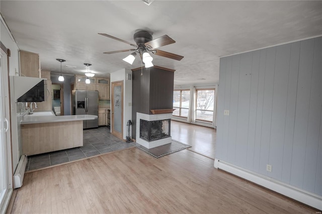 kitchen featuring pendant lighting, ceiling fan, stainless steel fridge with ice dispenser, and a baseboard radiator