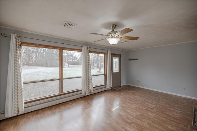 spare room featuring wood-type flooring, ceiling fan, and ornamental molding