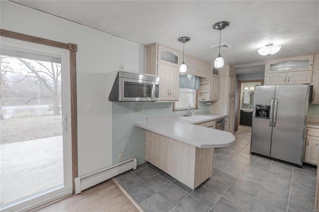 kitchen featuring kitchen peninsula, stainless steel appliances, a baseboard radiator, and plenty of natural light