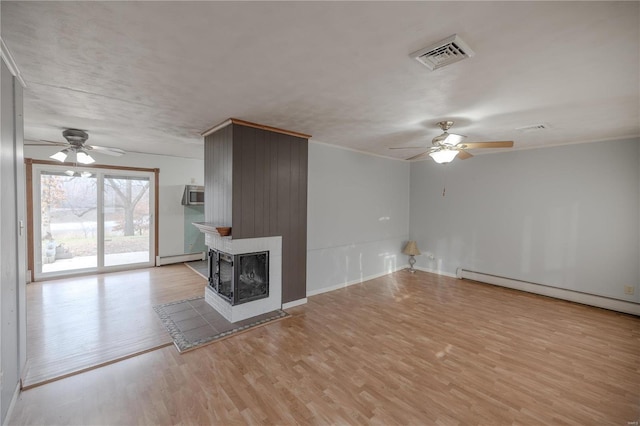 unfurnished living room featuring a multi sided fireplace, ceiling fan, a baseboard heating unit, and light wood-type flooring