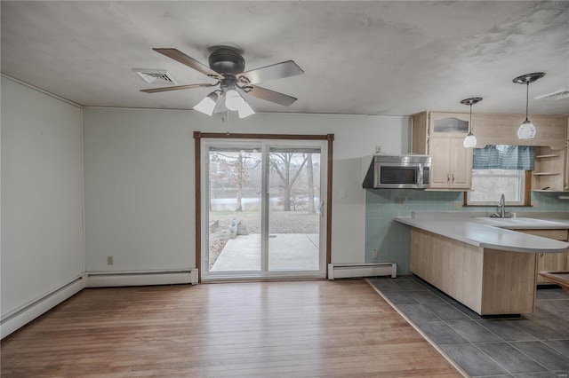 kitchen featuring a kitchen breakfast bar, hanging light fixtures, ceiling fan, a baseboard radiator, and kitchen peninsula