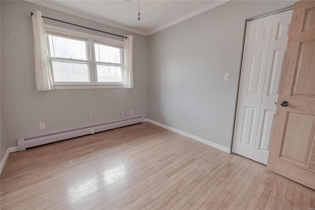 empty room with light wood-type flooring, ornamental molding, and a baseboard radiator