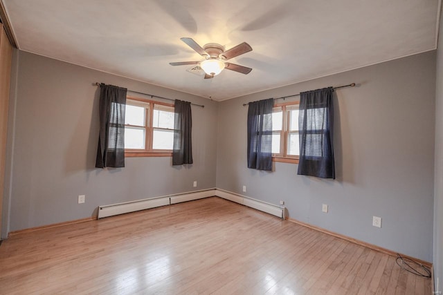 spare room featuring ceiling fan, a baseboard radiator, and light wood-type flooring