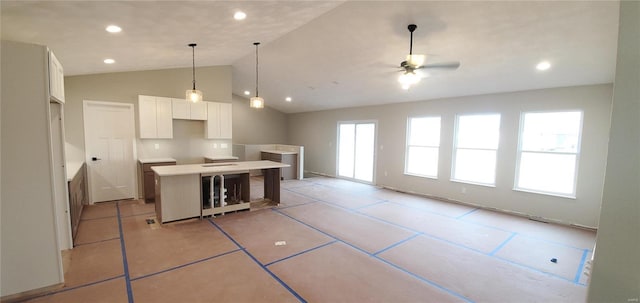 kitchen featuring ceiling fan, recessed lighting, a kitchen island, white cabinets, and vaulted ceiling