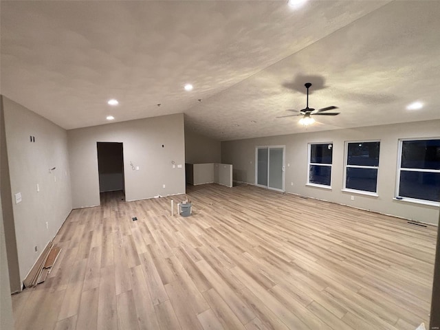 unfurnished living room featuring light wood finished floors, ceiling fan, vaulted ceiling, and recessed lighting