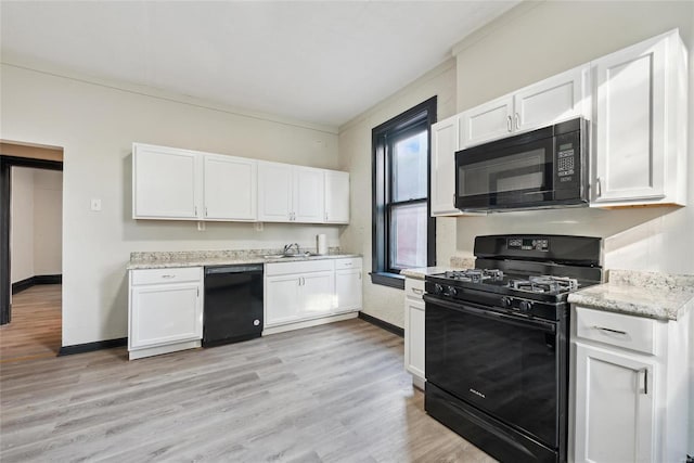 kitchen featuring sink, black appliances, white cabinets, and light hardwood / wood-style flooring