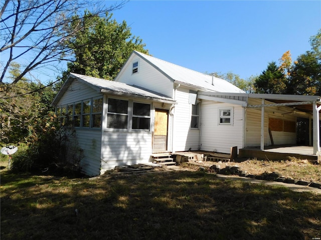 rear view of house featuring a lawn