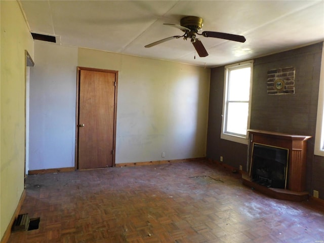 unfurnished living room with dark parquet flooring and ceiling fan