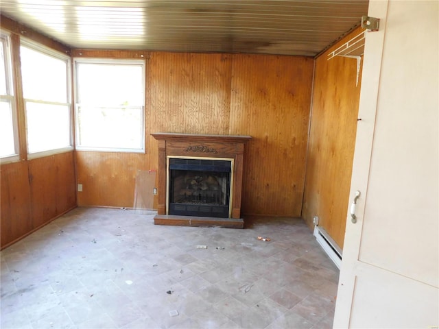 unfurnished living room featuring wood walls, wooden ceiling, and a baseboard heating unit