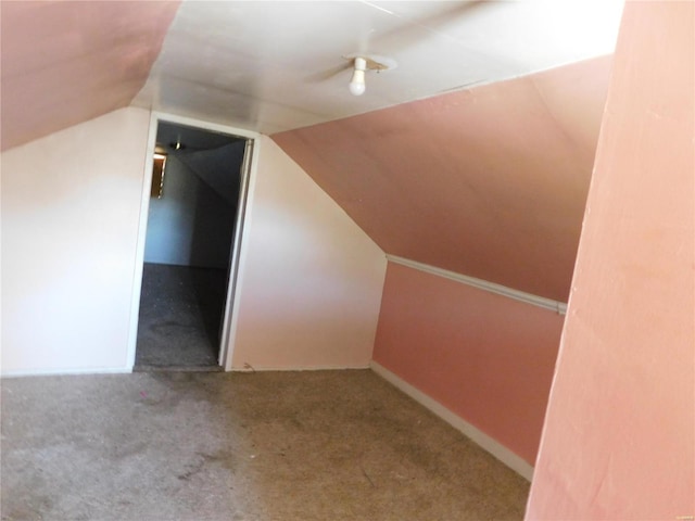 additional living space featuring lofted ceiling and carpet flooring