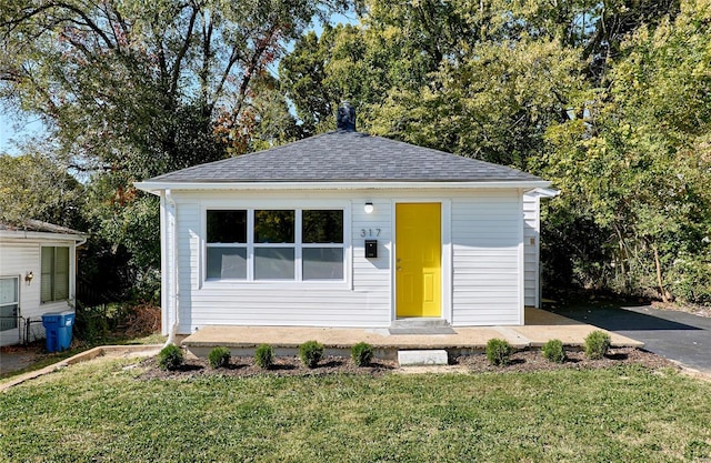 view of front of home featuring a front lawn and an outdoor structure