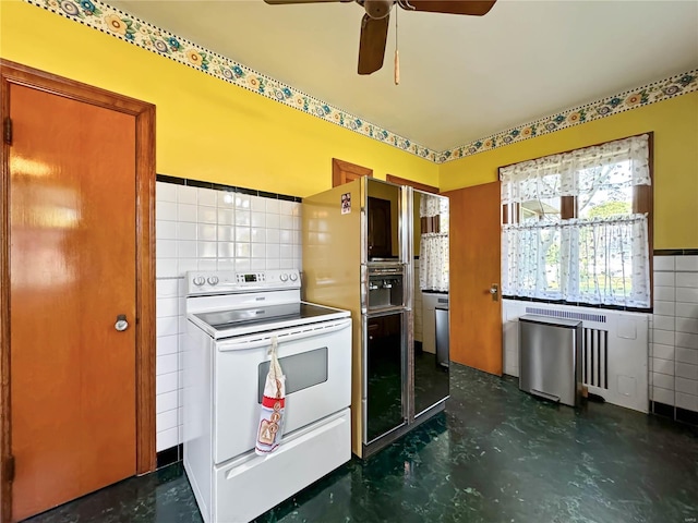 kitchen featuring tile walls, white electric range, and ceiling fan