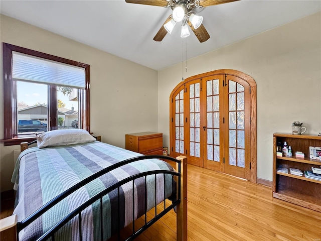 bedroom featuring french doors, light hardwood / wood-style floors, and ceiling fan