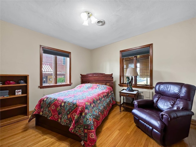 bedroom featuring multiple windows and light hardwood / wood-style flooring