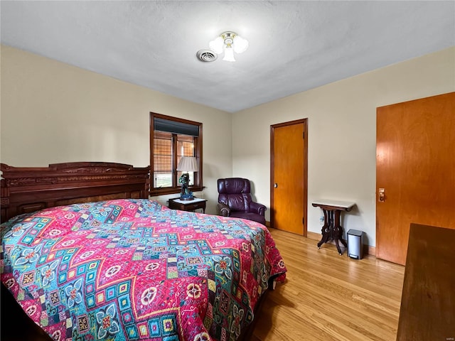 bedroom with a textured ceiling and light wood-type flooring