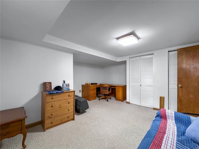 bedroom featuring two closets and light colored carpet