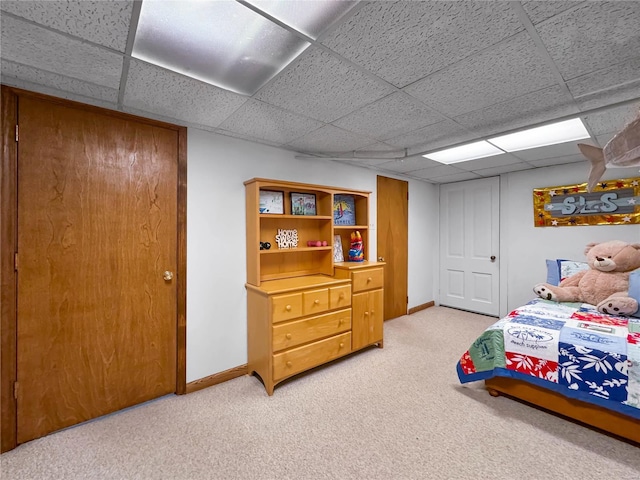 bedroom with a drop ceiling and carpet flooring