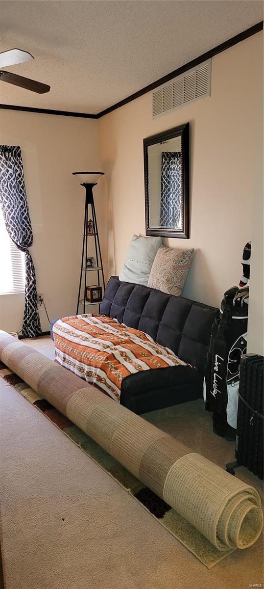 carpeted living room featuring ornamental molding and a textured ceiling