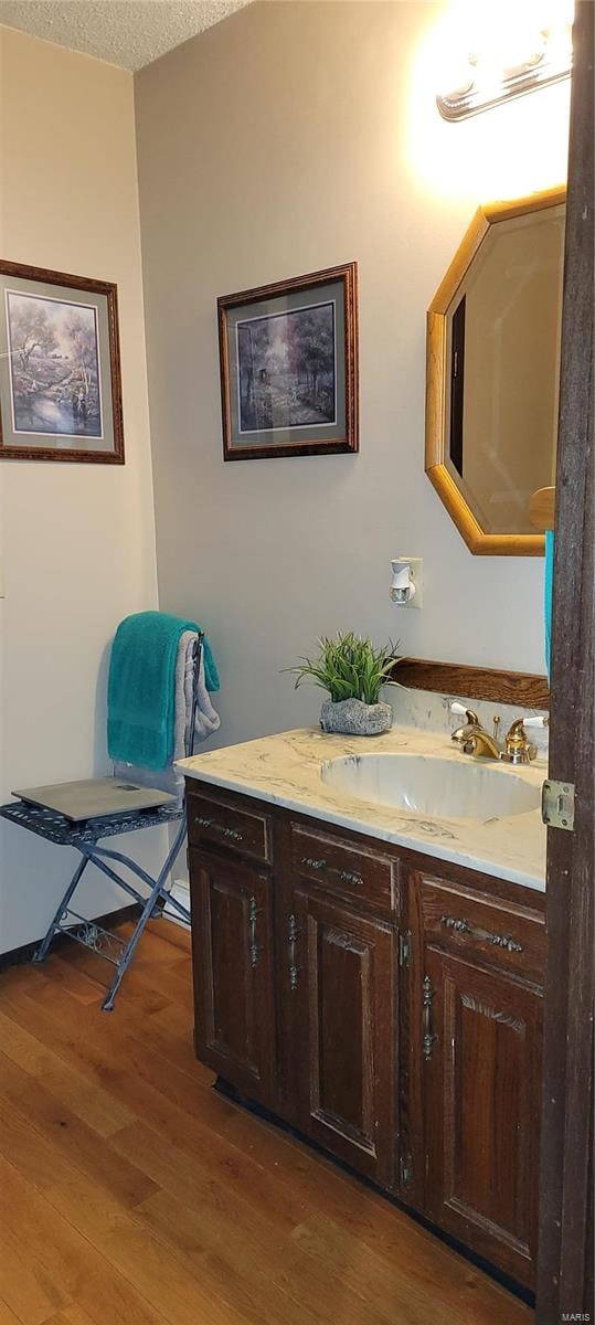 bathroom featuring vanity, hardwood / wood-style floors, and a textured ceiling