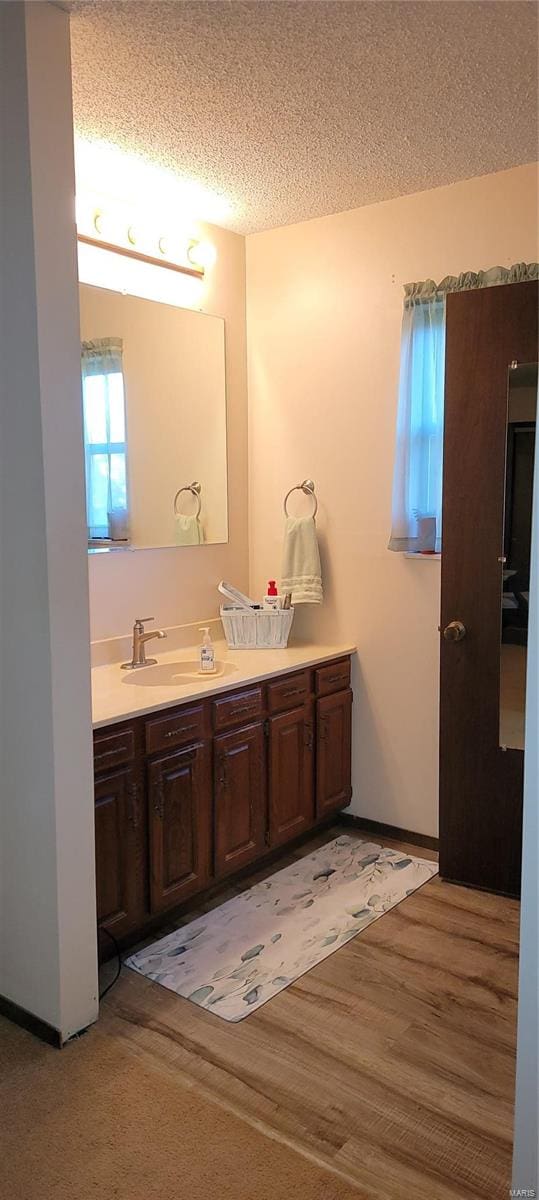 bathroom featuring vanity, a textured ceiling, and hardwood / wood-style floors