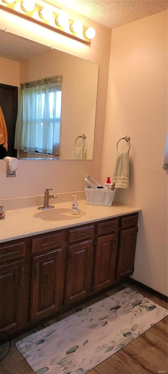 bathroom with vanity, a textured ceiling, and hardwood / wood-style floors