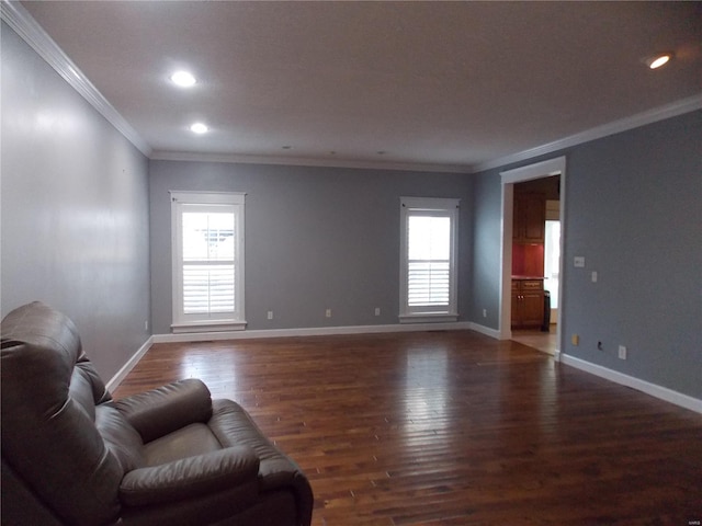 living room featuring dark wood-type flooring, a healthy amount of sunlight, and ornamental molding