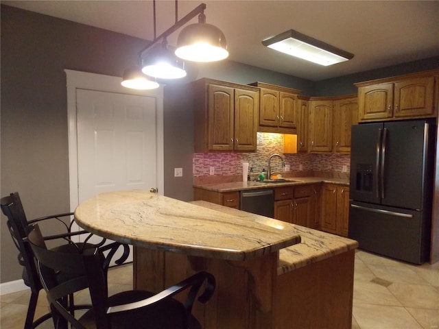 kitchen featuring sink, black fridge, backsplash, a center island, and dishwasher