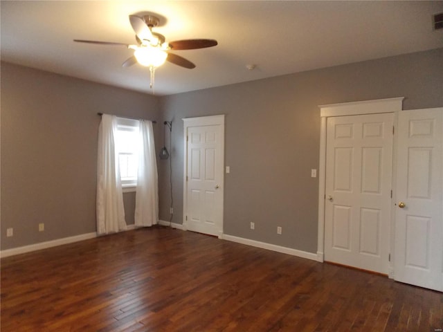 unfurnished bedroom featuring dark wood-type flooring and ceiling fan