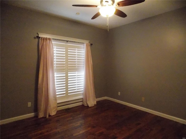 spare room featuring dark wood-type flooring and ceiling fan