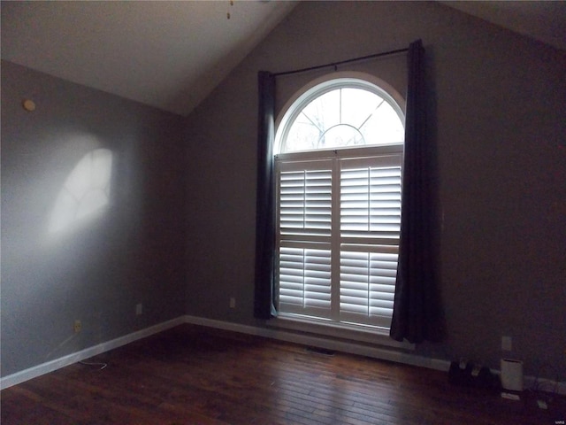 unfurnished room with dark wood-type flooring and vaulted ceiling