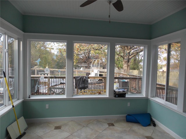 unfurnished sunroom featuring ceiling fan and a healthy amount of sunlight