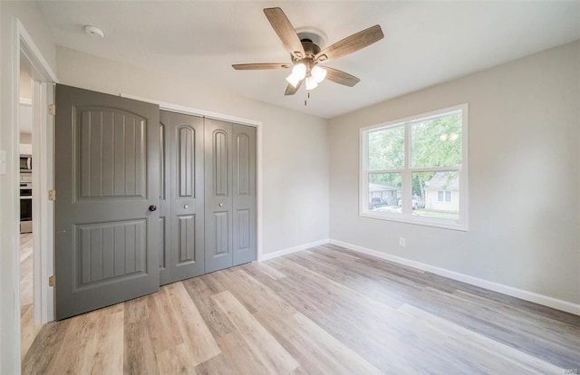 unfurnished bedroom featuring light hardwood / wood-style floors, ceiling fan, and a closet