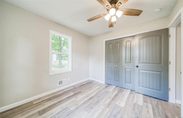 unfurnished bedroom featuring light hardwood / wood-style flooring, ceiling fan, and a closet