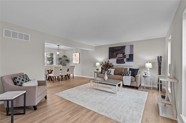 living room featuring light hardwood / wood-style flooring and a chandelier