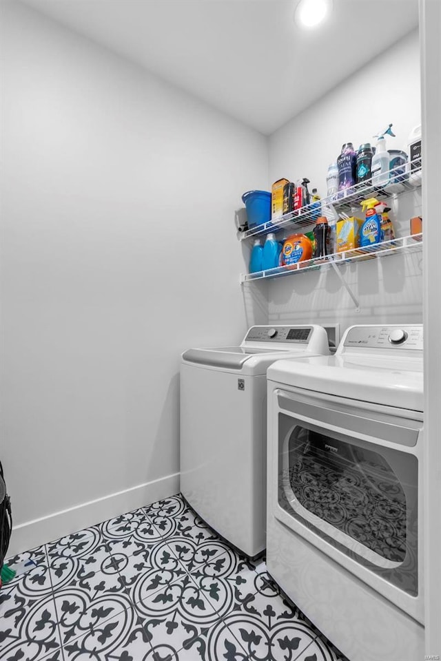 laundry area featuring light tile patterned floors and washer and clothes dryer