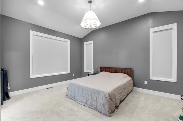 carpeted bedroom featuring lofted ceiling and a chandelier