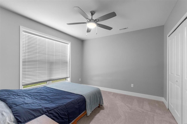 carpeted bedroom with a closet and ceiling fan