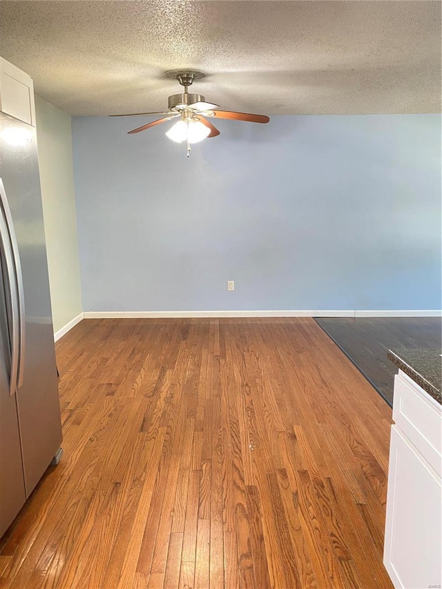 unfurnished room featuring a textured ceiling and light wood-type flooring