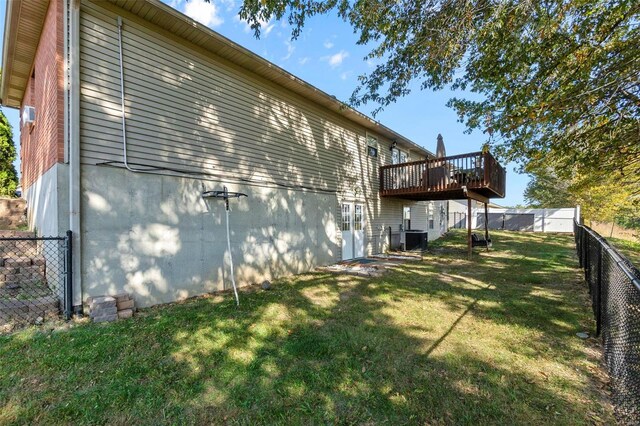 back of house featuring cooling unit, a yard, and a wooden deck