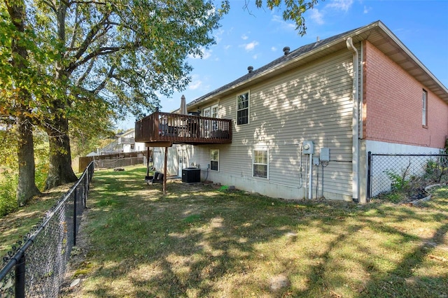 rear view of house with a yard, a deck, and central air condition unit