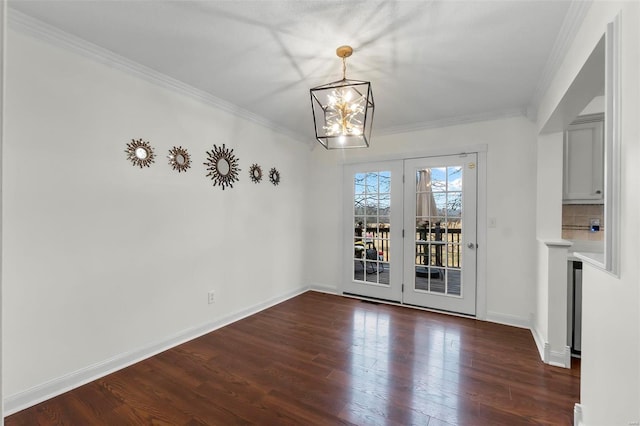 unfurnished dining area featuring an inviting chandelier, crown molding, and dark wood-type flooring