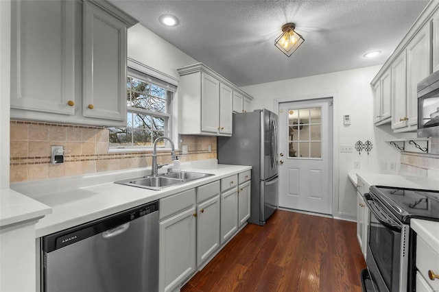 kitchen featuring stainless steel appliances, dark hardwood / wood-style floors, sink, and gray cabinetry