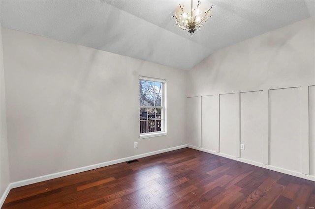 additional living space featuring lofted ceiling, a chandelier, a textured ceiling, and dark hardwood / wood-style flooring